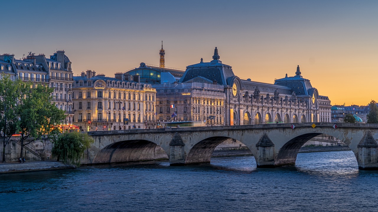 A river flows through Paris, with a bridge and multiple iconic buildings in view.