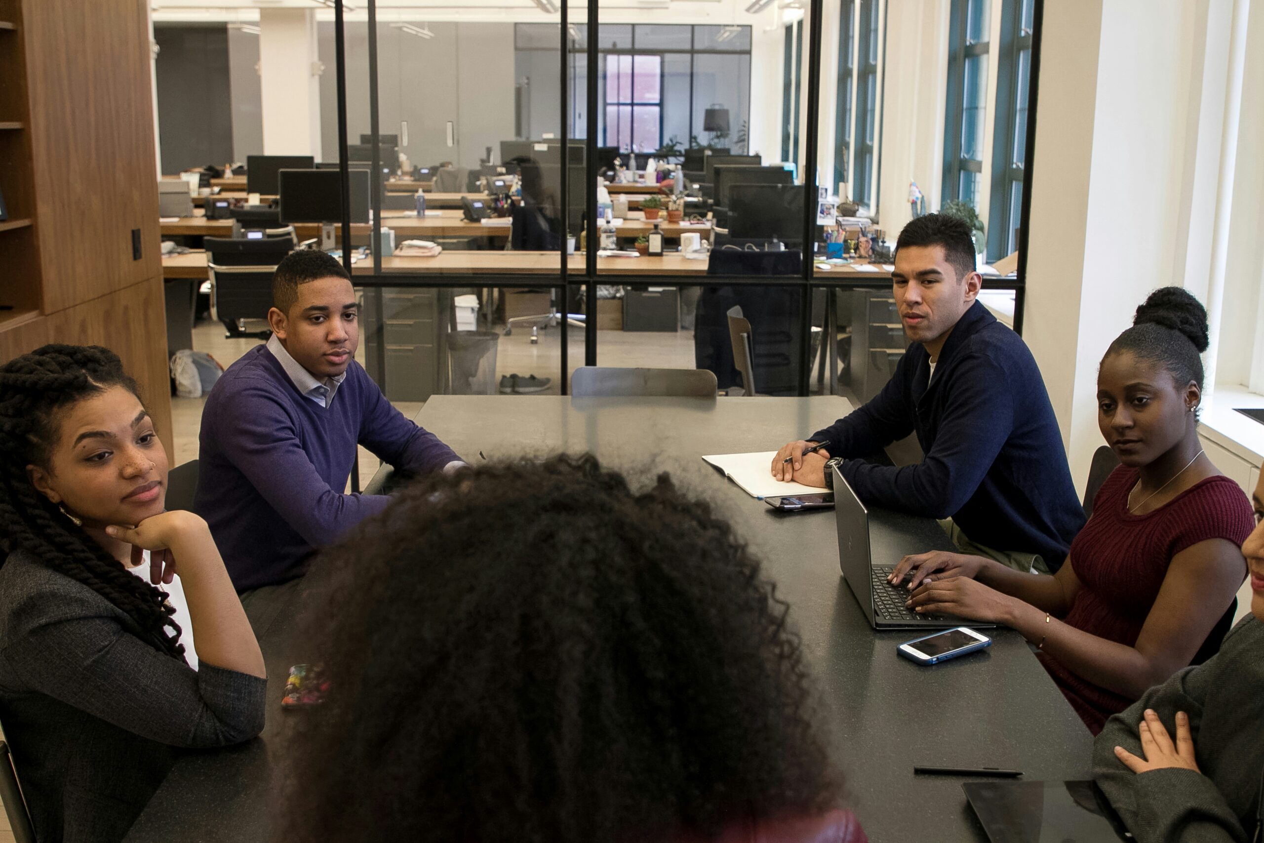 Collaborative team meeting in a modern office setting, showcasing diverse professionals engaged in productive discussion around a shared table.